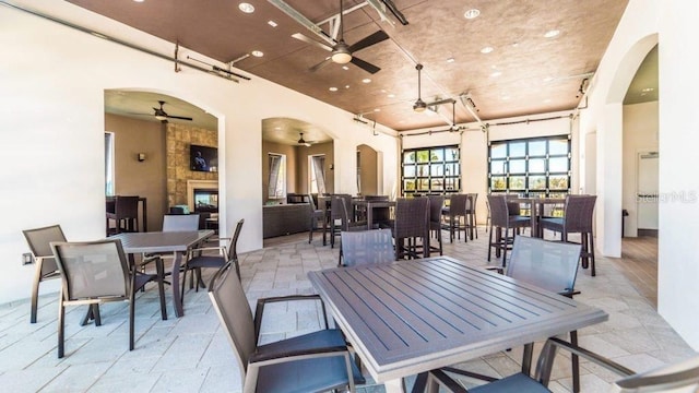 dining area with ceiling fan and a tile fireplace