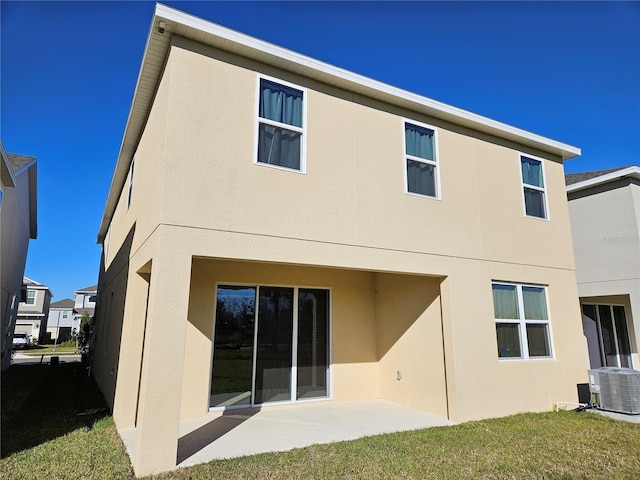 back of house with central air condition unit, a patio, and a lawn