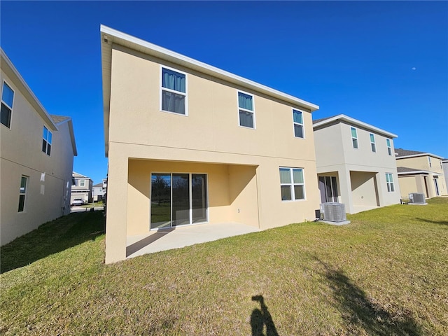 rear view of property featuring a yard, central AC, and a patio area