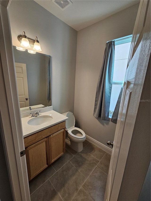 bathroom with vanity, toilet, and tile patterned flooring