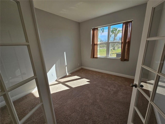 spare room featuring french doors and carpet flooring