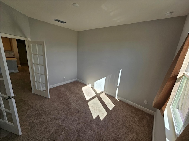 carpeted empty room featuring french doors