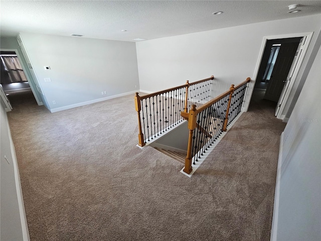 hallway featuring carpet and a textured ceiling