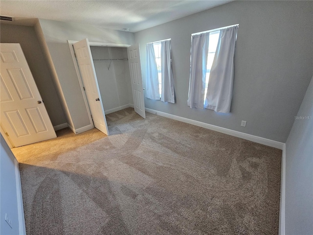 unfurnished bedroom with a closet and light carpet