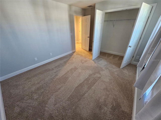 unfurnished bedroom with light colored carpet and a closet