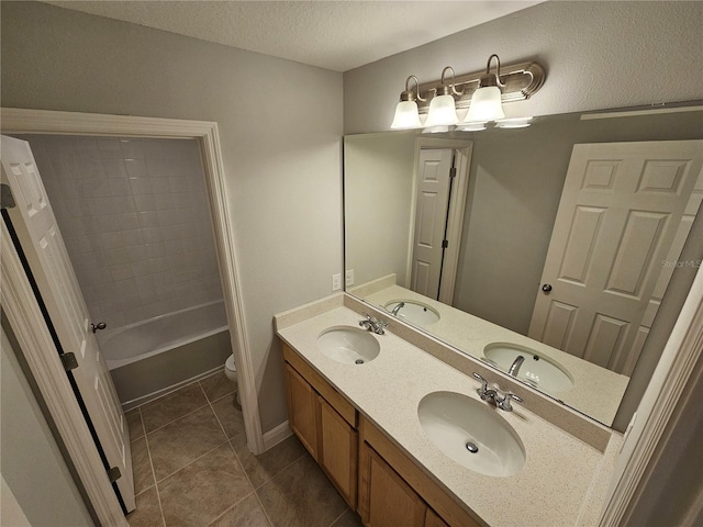 full bathroom featuring toilet,  shower combination, a textured ceiling, vanity, and tile patterned flooring