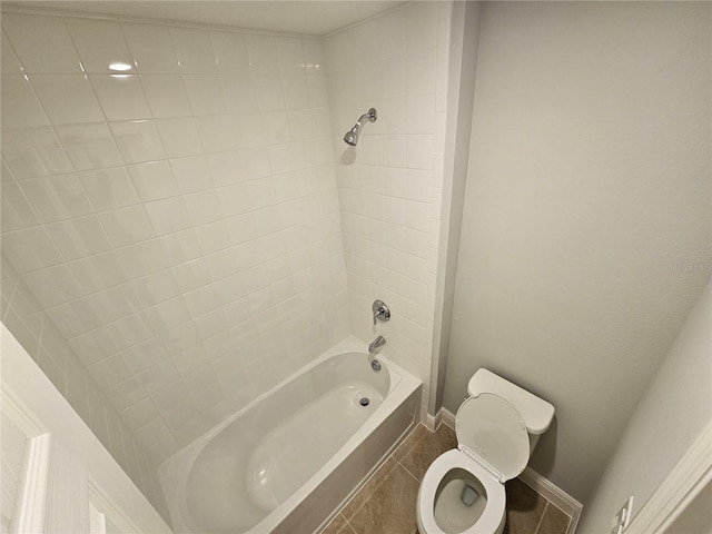 bathroom with tiled shower / bath, tile patterned floors, and toilet