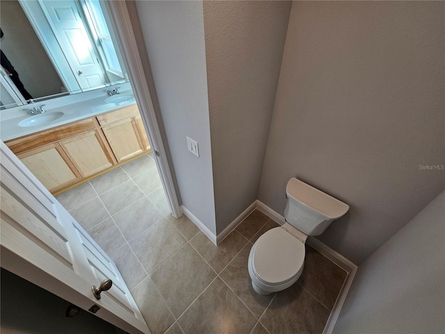 bathroom featuring tile patterned flooring, vanity, and toilet