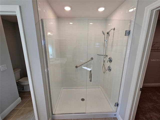 bathroom with walk in shower, toilet, and tile patterned flooring