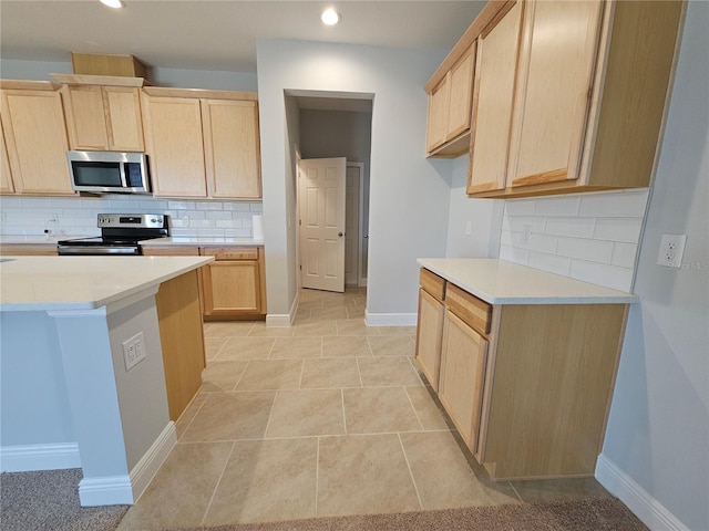 kitchen featuring light brown cabinetry, light tile patterned floors, decorative backsplash, and stainless steel appliances