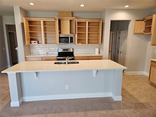 kitchen featuring sink, a kitchen breakfast bar, an island with sink, and appliances with stainless steel finishes