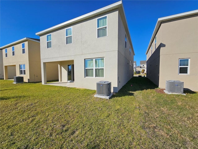 rear view of property with a lawn, a patio, and central air condition unit