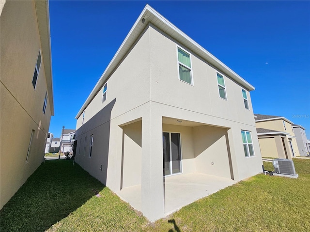 back of property with a yard, a patio, and central air condition unit