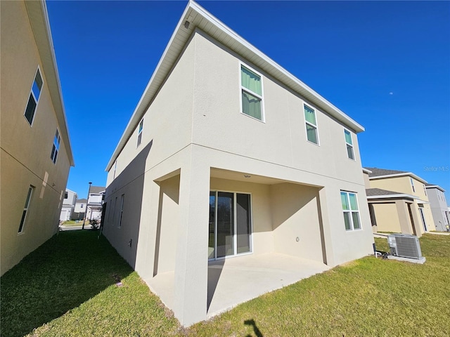 back of house featuring a patio, a yard, and central AC