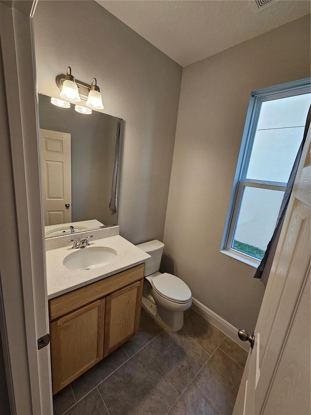 bathroom with vanity, tile patterned flooring, and toilet