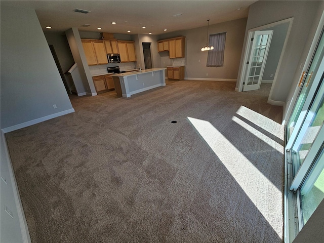 kitchen featuring a kitchen island, pendant lighting, carpet flooring, sink, and range