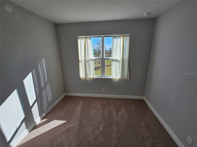 unfurnished room with dark carpet