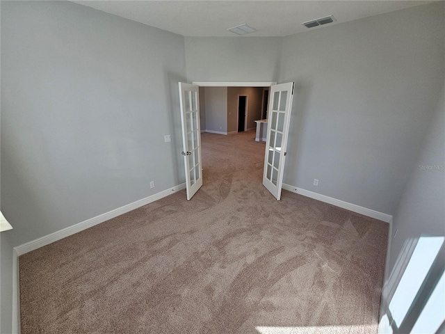 carpeted empty room featuring french doors