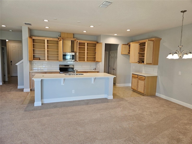 kitchen featuring pendant lighting, sink, stainless steel appliances, a kitchen breakfast bar, and a chandelier