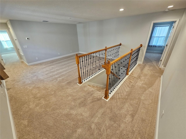 stairs with carpet and a textured ceiling