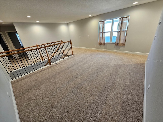 carpeted spare room featuring a textured ceiling