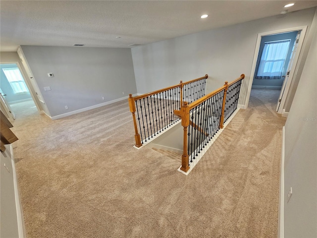 staircase with carpet flooring and a textured ceiling