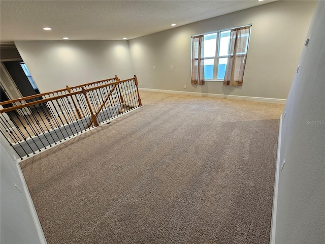 carpeted empty room with a textured ceiling