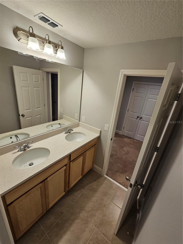 bathroom with vanity, tile patterned floors, and a textured ceiling