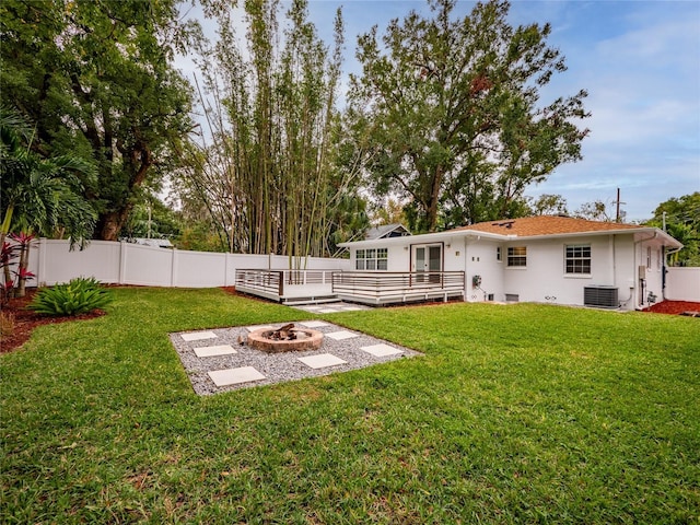 view of yard with a deck, central air condition unit, and an outdoor fire pit