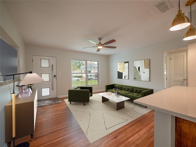 living room with ceiling fan and light hardwood / wood-style floors