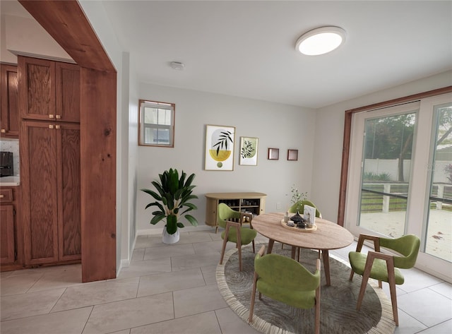 tiled dining space featuring a healthy amount of sunlight