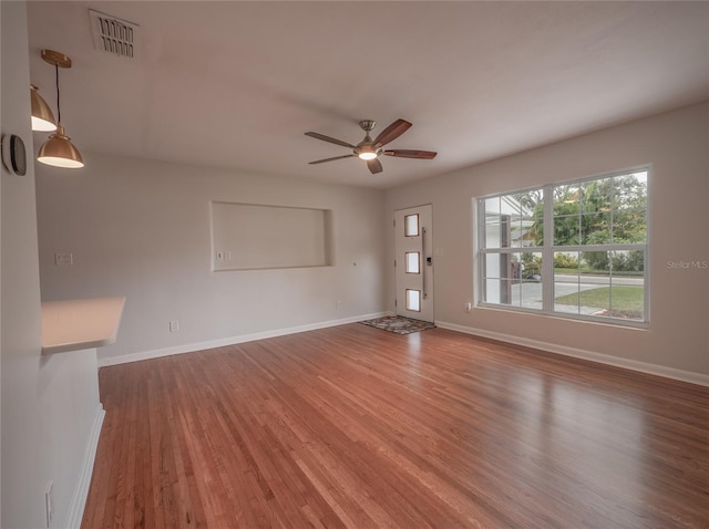 unfurnished living room featuring wood-type flooring and ceiling fan