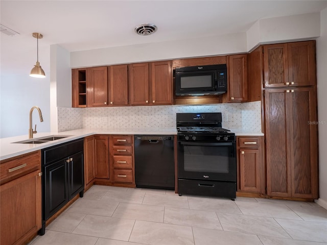 kitchen featuring pendant lighting, backsplash, black appliances, sink, and light tile patterned floors