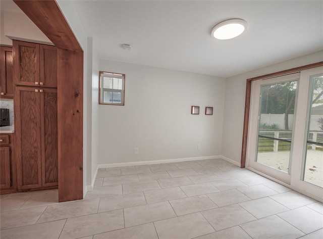 unfurnished room featuring plenty of natural light and light tile patterned floors