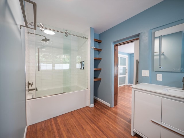 bathroom with hardwood / wood-style flooring, vanity, and combined bath / shower with glass door