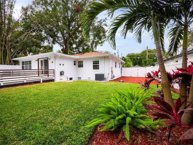 back of house featuring a lawn and central AC unit