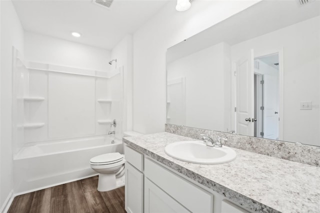 full bathroom with shower / tub combination, vanity, wood-type flooring, and toilet