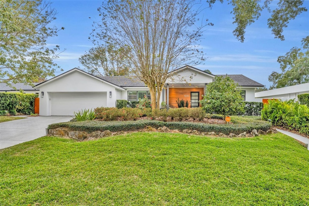 ranch-style house featuring a front yard and a garage