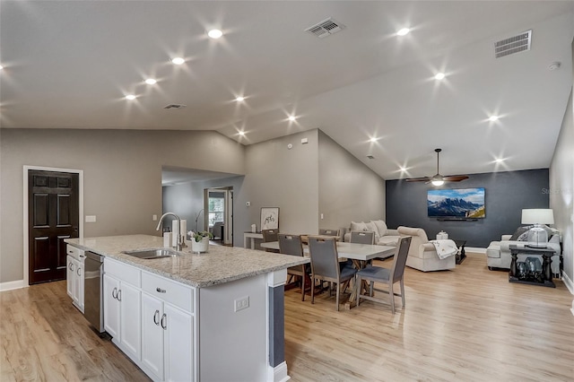 kitchen with light stone countertops, ceiling fan, a kitchen island with sink, sink, and white cabinetry