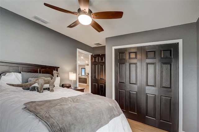 bedroom with ceiling fan, a closet, and light hardwood / wood-style flooring