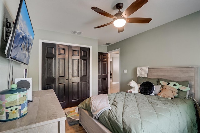 bedroom featuring ceiling fan, a closet, and hardwood / wood-style flooring