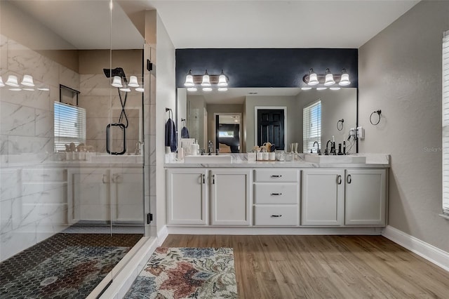 bathroom featuring hardwood / wood-style flooring, vanity, a healthy amount of sunlight, and walk in shower