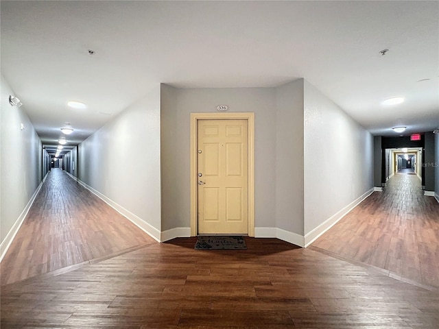 corridor with dark hardwood / wood-style flooring