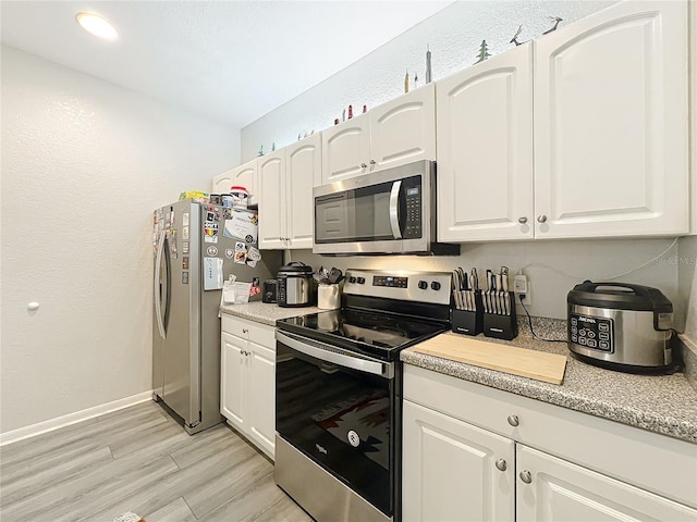 kitchen with white cabinetry, light hardwood / wood-style flooring, and stainless steel appliances