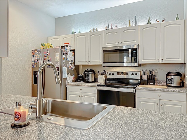 kitchen with sink, white cabinets, and appliances with stainless steel finishes