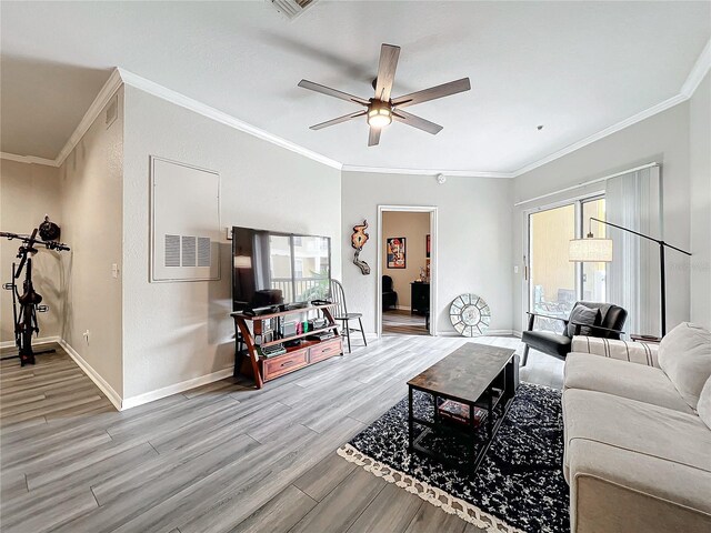 living room with wood-type flooring, ornamental molding, and ceiling fan