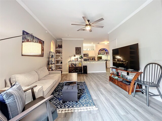 living room featuring wood-type flooring, ornamental molding, and ceiling fan