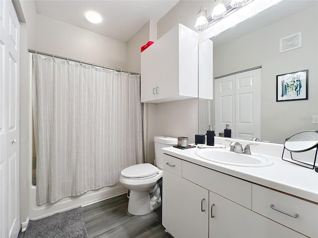 full bathroom featuring vanity, hardwood / wood-style floors, shower / bath combo, and toilet