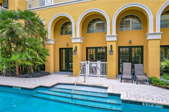 back of house featuring a patio, a community pool, and french doors