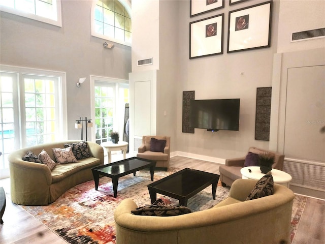 living room featuring wood-type flooring and a high ceiling